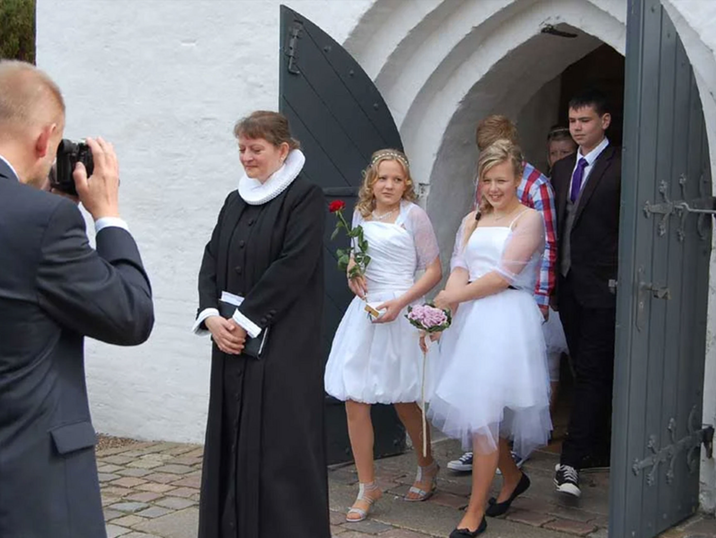 Kirkeceremoni med præst og konfirmander.